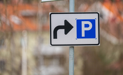 Sign showing the directions to a parking lot.