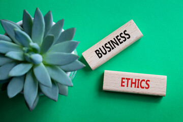 Business ethics symbol. Concept word Business ethics on wooden blocks. Beautiful green background...