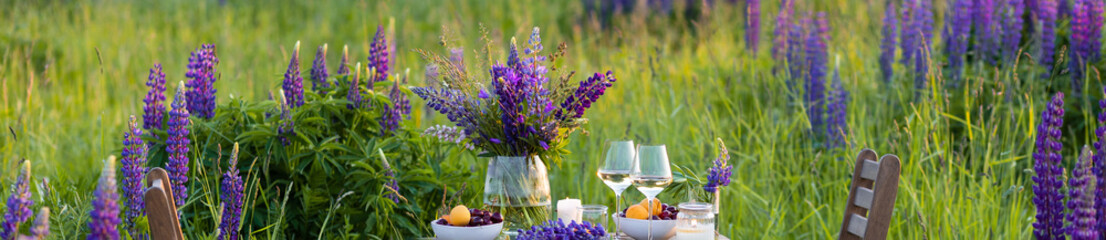 Elegant gorgeous wedding table decor or romantic dinner arrangement outdoors in blooming field....