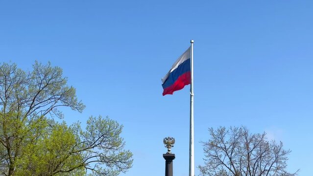 the Russian flag flies against the background of the blue sky 