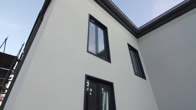 Metal plastic windows installed on elegant renovated building facade in city. Integration of modern technology in old architecture style