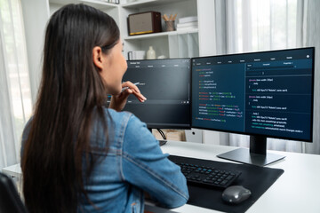 Young Asian IT developer looking online information on pc for beautiful pose with coding program data of website application, wearing jeans shirt. surround by safety analysis two screens. Stratagem.