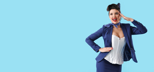 Attractive pin-up stewardess saluting on blue background