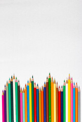Frame made by waves of colored pencils. Back to school. School supplies.