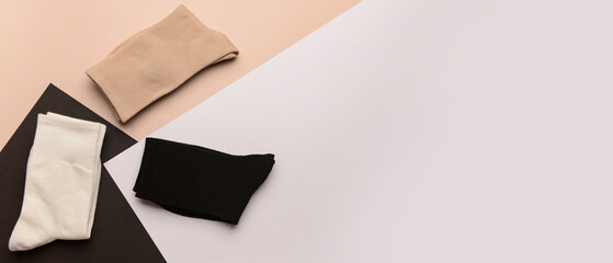 Stylish folded socks on beige background with space for text