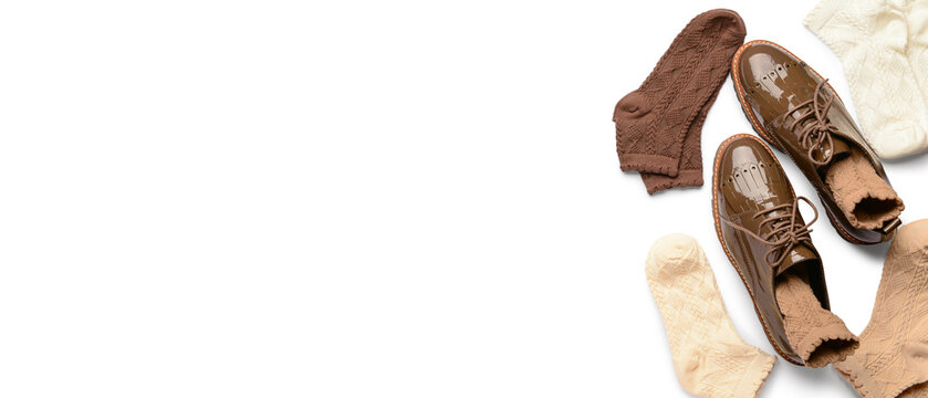 Stylish socks with leather shoes on white background with space for text