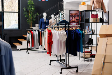 Empty fashion store with casual and formal wear design, retail shop with stylish clothes on hangers...