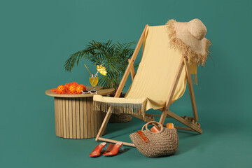 Deckchair, beach accessories, glass of cocktail and oranges on color background