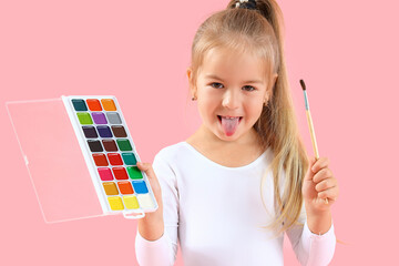 Cute little girl with paints and brush on pink background