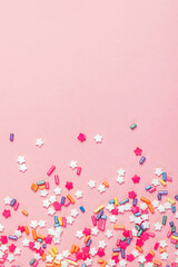 Festive sugar sprinkles on pastel pink background