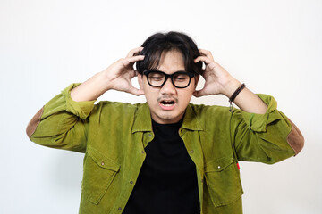 Portrait of young Asian man isolated on white background feeling frustrated with helpless facial...