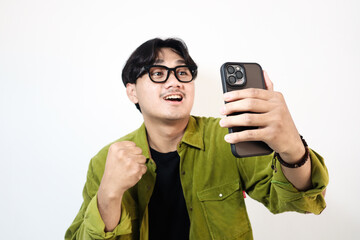 Young Asian man with happy smiling face about what he see in the smartphone on isolated white background	