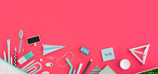 School stationery, notebooks, paper plane on pink desk. Back to school concept.	
