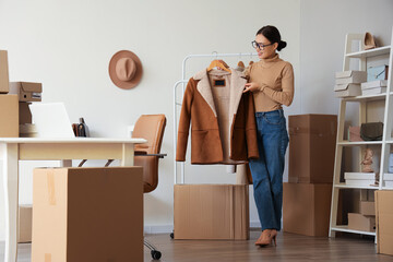 Female Asian seller with sheepskin coat in warehouse store