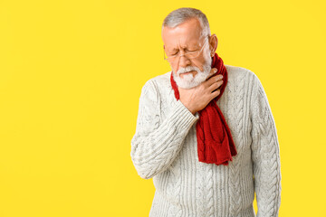 Ill old man with sore throat on yellow background