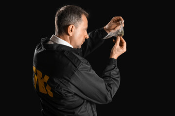 Mature FBI agent with evidence on black background