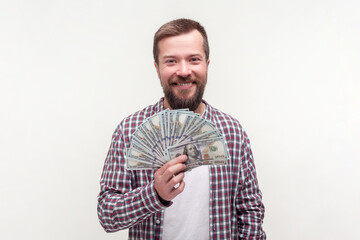 Portrait of satisfied happy positive bearded man holding dollar banknotes salary reward winning...