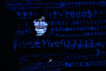 Hacker with projection of programming code on dark background