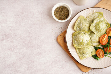 Plate of tasty ravioli with tomatoes and cheese on white background