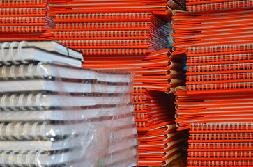 stack of orange and white notebooks with spiral wire ties. stock and products of the printing...