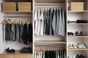 Rack with stylish male clothes and accessories in modern wardrobe