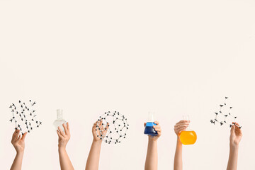 Female hands holding filled flasks with molecular models on white background. Chemistry lesson...