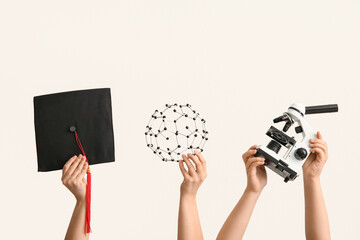 Female hands holding graduation hat with microscope and molecular model on white background....