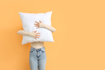 Woman with white pillow on orange background