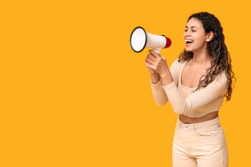Young African-American woman with megaphone on yellow background