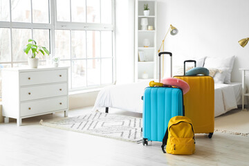 Suitcases with travel accessories in hotel room