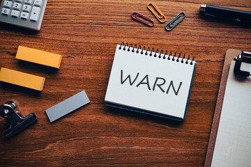 There is notebook with the word WARN. It is as an eye-catching image.