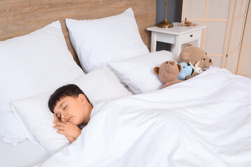 Obraz na płótnie Canvas Cute little boy with toys sleeping in bedroom