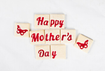 Cute square shortbread cookies with marmalade filling in the shape of the words happy mother's day and butterfly. White background. Top view. Mothers Day