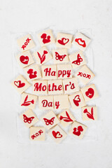 Mother's Day dessert. Delicate square shortbread cookies with red marmalade filling in a thematic form, happy mother's day, mom, flower, butterfly, mother and child, hearts. White background. Top view