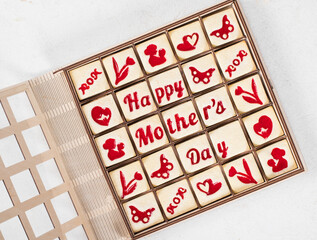 Mothers Day dessert. Delicate square cookies with marmalade filling in a thematic form, happy mother's day, mom, flower, butterfly, mother and child, hearts. In a wooden gift box. Top view