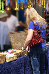 Blonde woman in blue shirt shopping at crafts stall