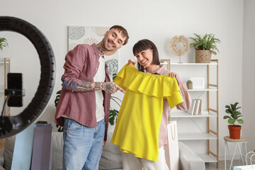 Couple of fashion bloggers with clothes recording video at home