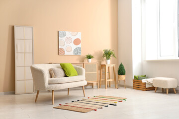 Interior of light living room with sofa near beige wall