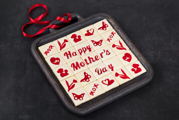 Mother's Day. Square shortbread cookies with marmalade filling in a thematic form, happy mother's day, mom, flower, butterfly, mother and child, hearts. Decorated with a red satin ribbon. 