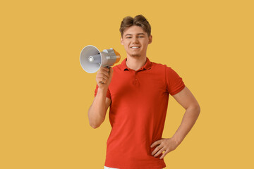 Male lifeguard with loudspeaker on yellow background