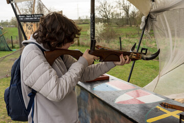 A teenager shoots a recreational crossbow at a shooting range.