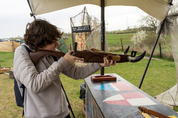 A teenager shoots a recreational crossbow at a shooting range.