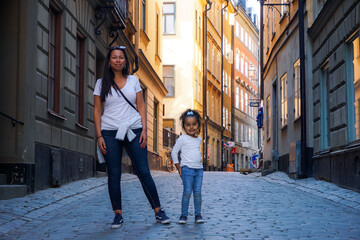 Portrait of mother and daughter standing on city street