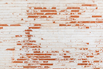 Detalle de una pared de ladrillos pintados de blanco desconchada, textura