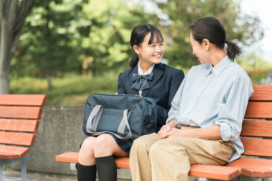 公園のベンチで笑顔で会話する女性・親子・母娘・中学生・教師・先生

