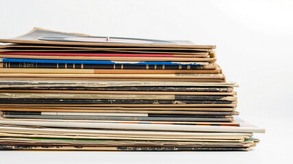 Stack of old, worn record covers, evoking nostalgia and the passage of time.
