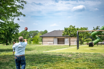 Grandpa playing catch with a football at a park