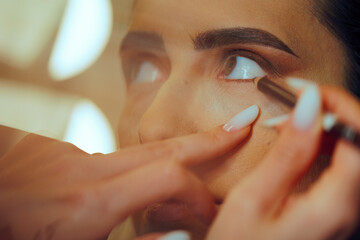 Skillful Makeup Artist Applying Eye pencil on Waterline. Woman having her looks changed through...
