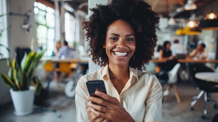 Portrait happy young african businesswoman using smartphone in the office