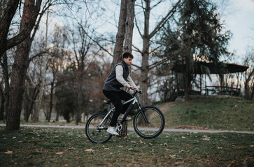 Fototapeta premium Young male teenager rides his bicycle outdoors, experiencing the joy of leisure time in a natural setting.